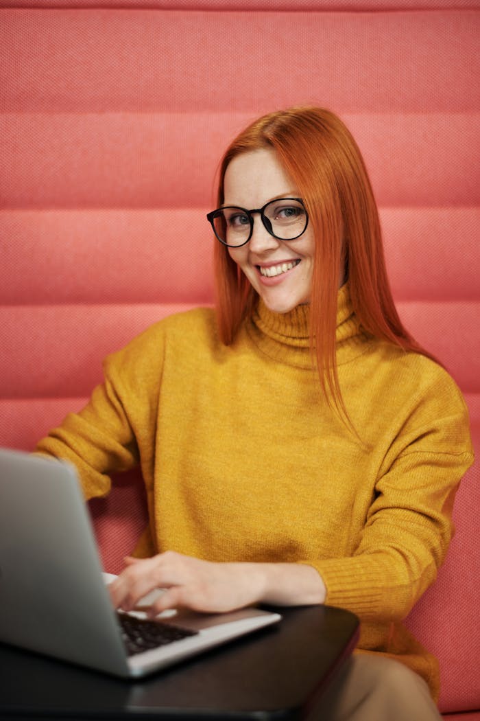 A Smiling Woman Wearing a Yellow Sweater and Eyeglasses